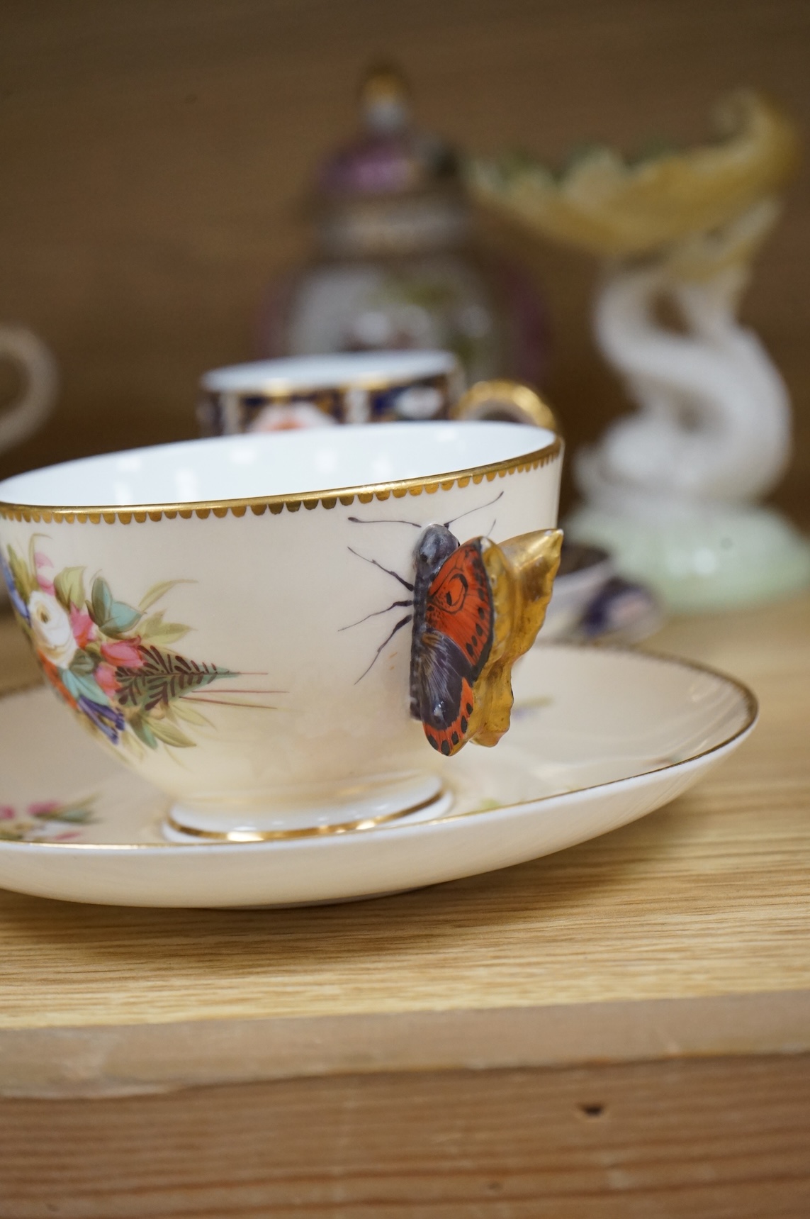 A Worcester butterfly handled cup and saucer and four other items, together with Royal Crown Derby, Dresden and Coalport items. (9). Tallest 13 cm